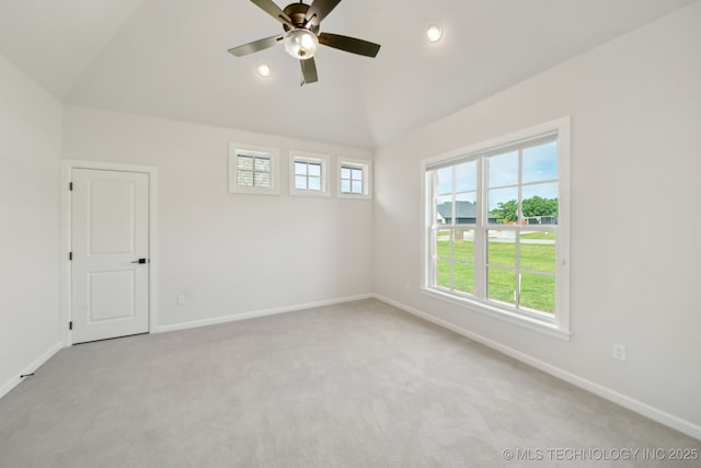 empty room featuring healthy amount of natural light, lofted ceiling, baseboards, ceiling fan, and carpet