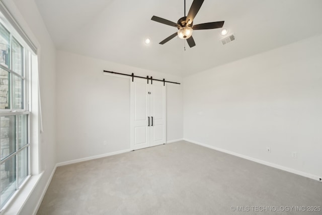 unfurnished room with a barn door, carpet flooring, ceiling fan, baseboards, and recessed lighting