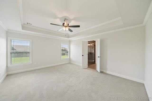 unfurnished bedroom with a raised ceiling, ornamental molding, multiple windows, and light carpet
