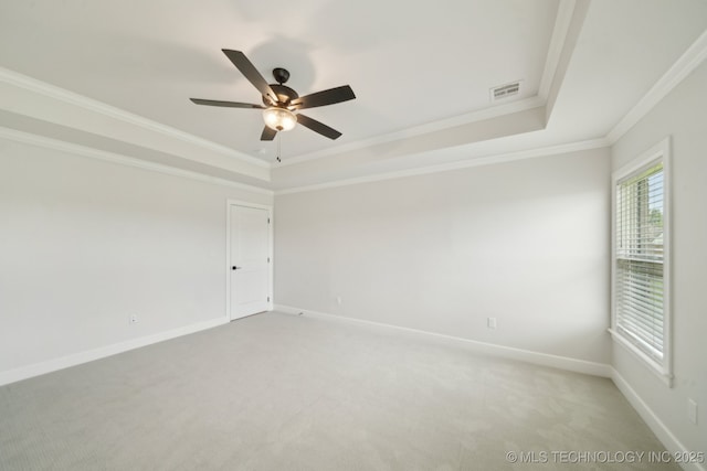 unfurnished room with a tray ceiling, crown molding, light carpet, ceiling fan, and baseboards