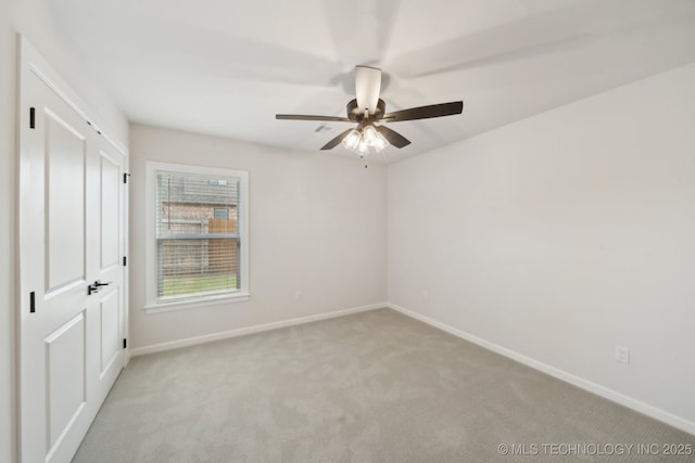 unfurnished bedroom with light carpet, baseboards, and a ceiling fan