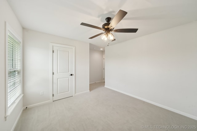 unfurnished bedroom featuring baseboards, light colored carpet, and ceiling fan