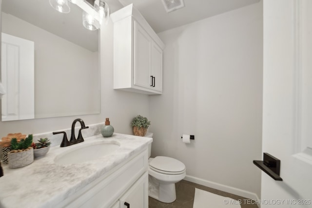 half bath featuring vanity, tile patterned floors, toilet, and baseboards
