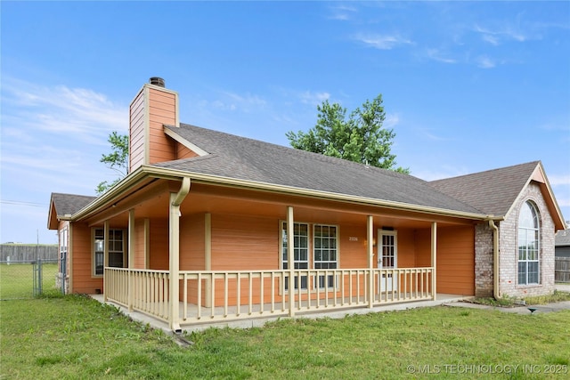 view of front of property featuring a porch, a chimney, a shingled roof, and brick siding
