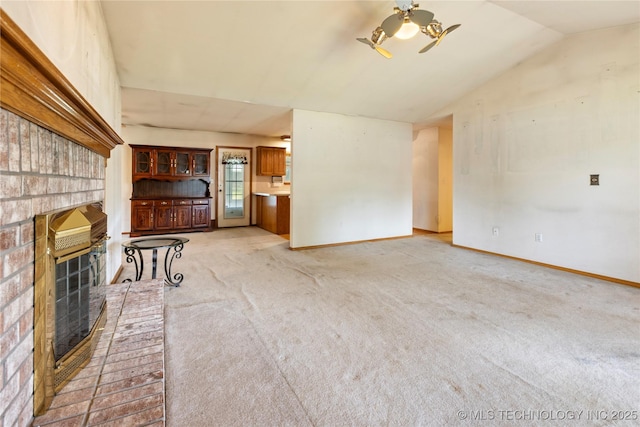 unfurnished living room featuring a brick fireplace, light carpet, lofted ceiling, and baseboards