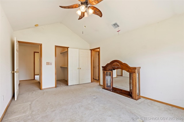 unfurnished bedroom featuring vaulted ceiling, light carpet, baseboards, and ceiling fan