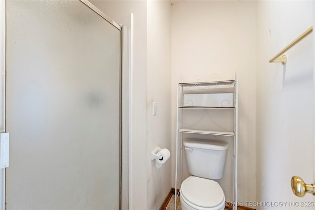 bathroom featuring a shower stall and toilet