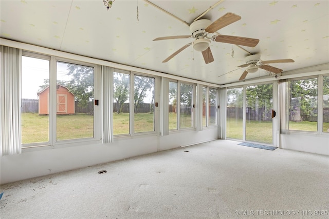 unfurnished sunroom featuring plenty of natural light and carpet flooring