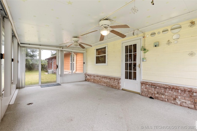 unfurnished sunroom with ceiling fan