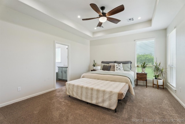 9429 Bryan Rd, Shawnee, OK 74855 - carpeted bedroom featuring baseboards, multiple windows, recessed lighting, a tray ceiling, and ensuite bath
