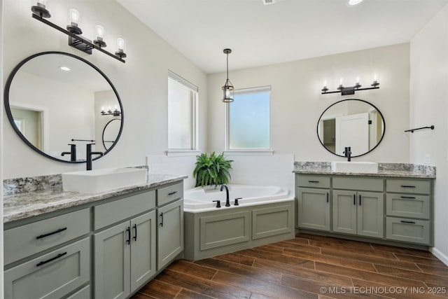 9429 Bryan Rd, Shawnee, OK 74855 - full bathroom featuring wood finished floors, two vanities, a bath, and recessed lighting