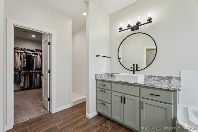 9429 Bryan Rd, Shawnee, OK 74855 - full bathroom featuring wood tiled floors, vanity, a walk in closet, baseboards, and walk in shower