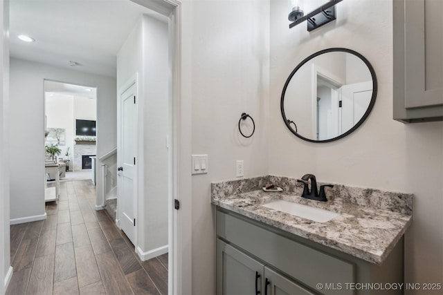 9429 Bryan Rd, Shawnee, OK 74855 - bathroom with wood finished floors, vanity, recessed lighting, a glass covered fireplace, and baseboards