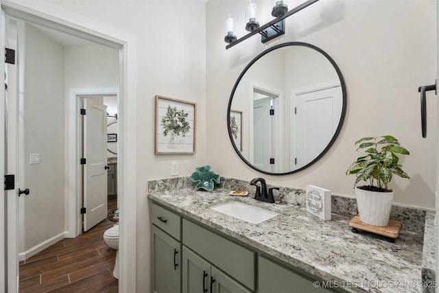 9429 Bryan Rd, Shawnee, OK 74855 - bathroom with wood finished floors, toilet, vanity, and baseboards