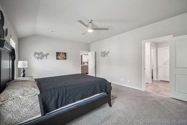 carpeted bedroom featuring vaulted ceiling, a ceiling fan, baseboards, and tile patterned floors