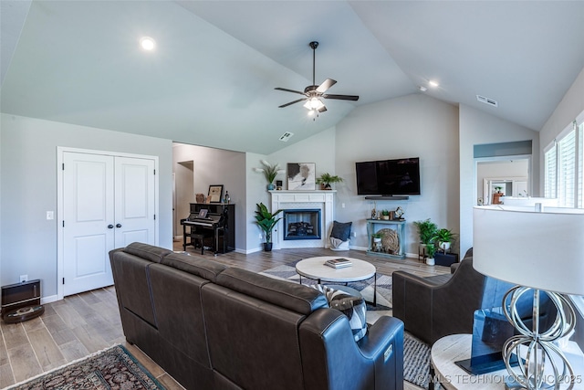 15922 E 75th Pl N, Owasso, OK 74055 - living area featuring lofted ceiling, ceiling fan, baseboards, wood finished floors, and a fireplace