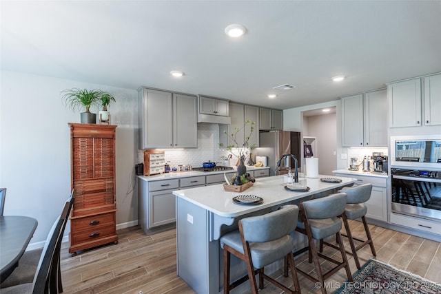 15922 E 75th Pl N, Owasso, OK 74055 - kitchen featuring appliances with stainless steel finishes, gray cabinets, wood finish floors, and recessed lighting