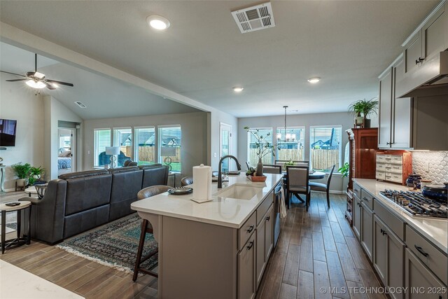15922 E 75th Pl N, Owasso, OK 74055 - kitchen featuring a sink, stainless steel appliances, dark wood finished floors, a breakfast bar area, and gray cabinets