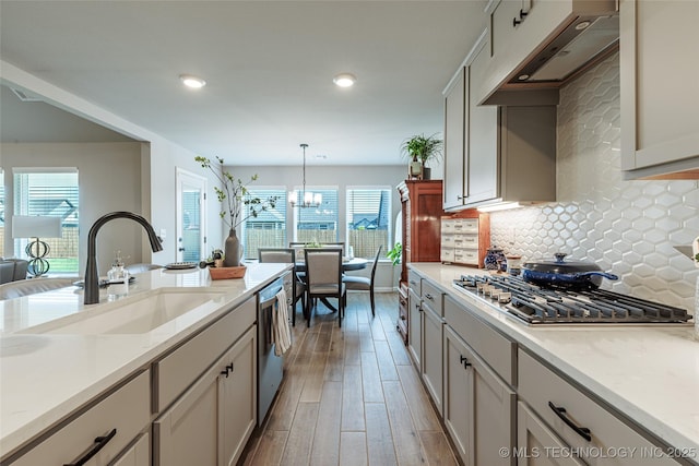 15922 E 75th Pl N, Owasso, OK 74055 - kitchen with a sink, appliances with stainless steel finishes, light wood-style flooring, decorative backsplash, and custom exhaust hood