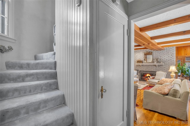2815 S Woodward Blvd, Tulsa, OK 74114 - staircase with a fireplace, beam ceiling, wood finished floors, and brick wall