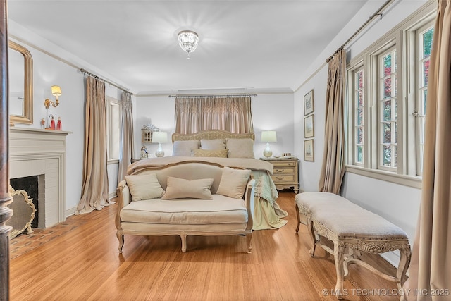2815 S Woodward Blvd, Tulsa, OK 74114 - bedroom featuring light wood finished floors, ornamental molding, and a brick fireplace