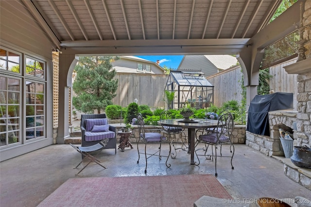 2815 S Woodward Blvd, Tulsa, OK 74114 - view of patio / terrace featuring a fenced backyard, outdoor dining area, grilling area, an outdoor structure, and a greenhouse