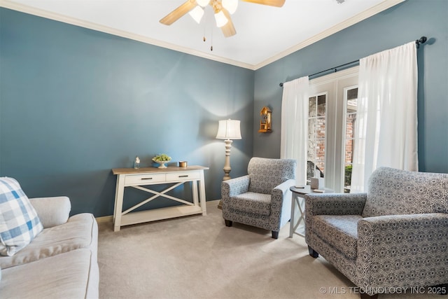 sitting room featuring a ceiling fan, carpet floors, and ornamental molding