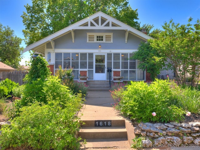 1618 S Rockford Ave, Tulsa, OK 74120 - view of front of property featuring a sunroom, fence, entry steps, and a chimney