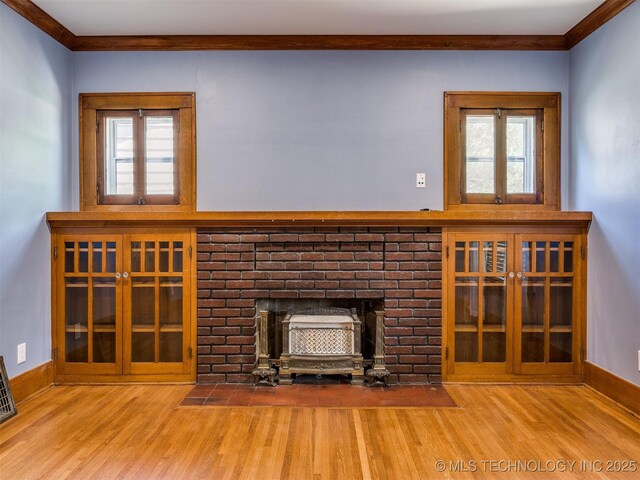 1618 S Rockford Ave, Tulsa, OK 74120 - unfurnished living room featuring wood finished floors, crown molding, a fireplace, plenty of natural light, and baseboards