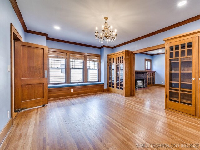 1618 S Rockford Ave, Tulsa, OK 74120 - unfurnished living room with a chandelier, light wood finished floors, crown molding, plenty of natural light, and a brick fireplace