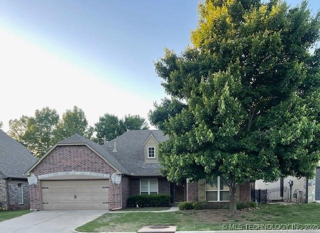 view of front of home with brick siding, an attached garage, and concrete driveway