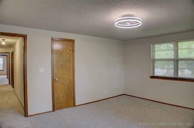 8242 S Sandusky Ave, Tulsa, OK 74137 - unfurnished bedroom featuring light carpet, a textured ceiling, and baseboards