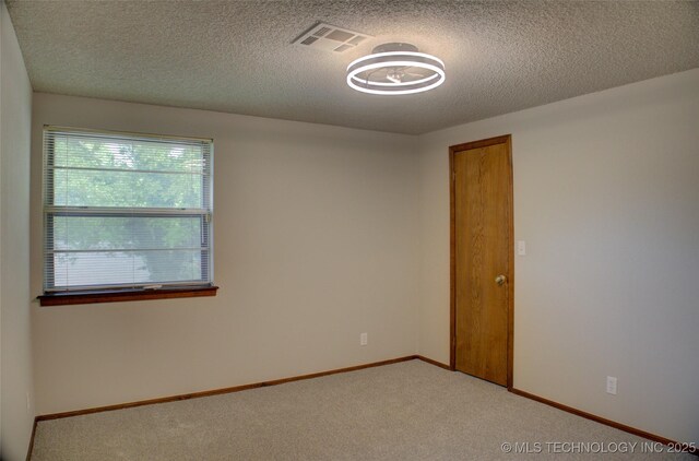 8242 S Sandusky Ave, Tulsa, OK 74137 - spare room with light carpet, a textured ceiling, and baseboards
