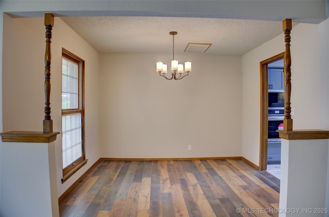 8242 S Sandusky Ave, Tulsa, OK 74137 - spare room with a chandelier, wood finished floors, baseboards, and a textured ceiling