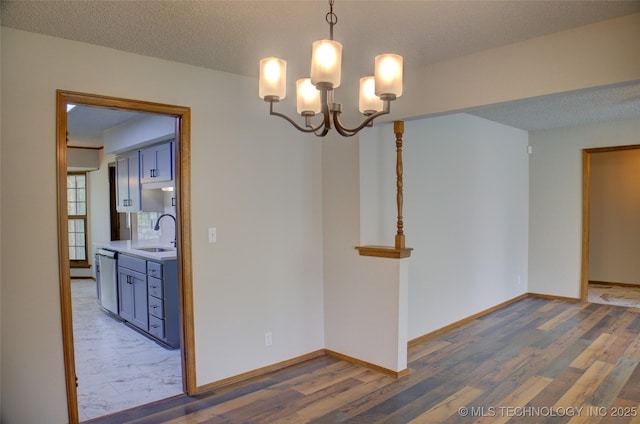 8242 S Sandusky Ave, Tulsa, OK 74137 - empty room featuring a sink, a chandelier, wood finished floors, and baseboards
