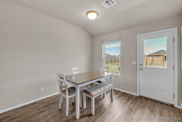 dining room featuring wood finished floors, lofted ceiling, and baseboards