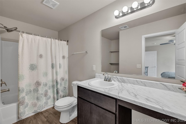 ensuite bathroom with wood finished floors, vanity, toilet, and shower / tub combo with curtain