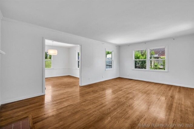1223 E 31st St, Tulsa, OK 74105 - empty room with wood finished floors, crown molding, and baseboards