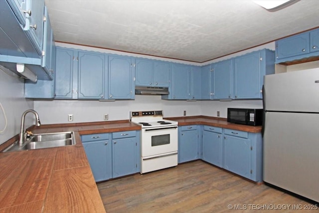 kitchen with freestanding refrigerator, white electric range, blue cabinetry, a sink, and black microwave