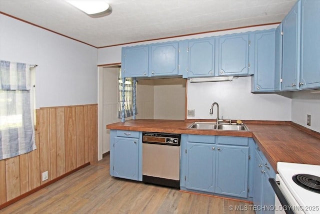 kitchen with dishwasher, blue cabinetry, a sink, light wood finished floors, and wood walls
