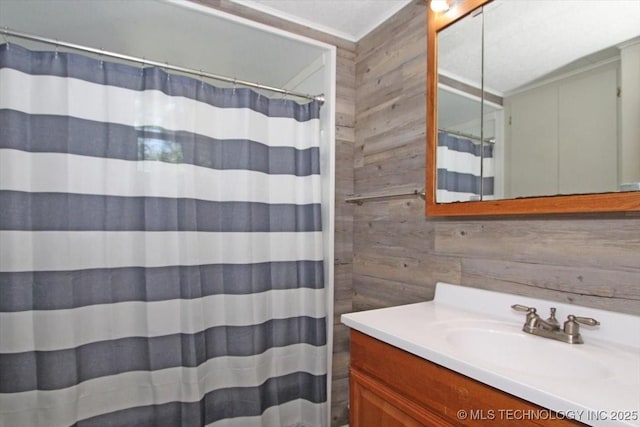 full bath featuring wooden walls, vanity, and a shower with curtain