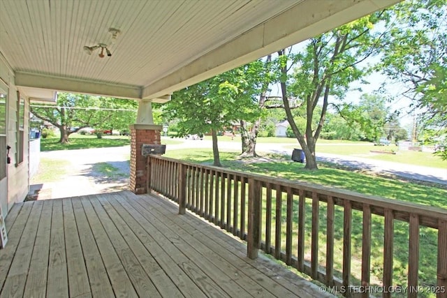 wooden deck featuring a yard and covered porch