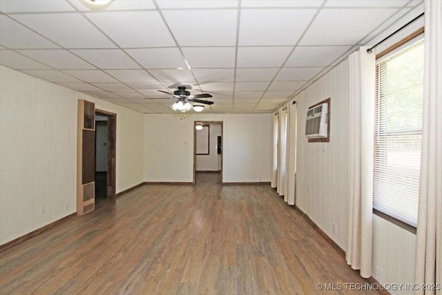 unfurnished room with wood finished floors, ceiling fan, a paneled ceiling, and baseboards
