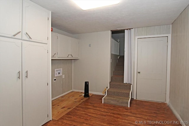 washroom with cabinet space, washer hookup, dark wood-style floors, and baseboards