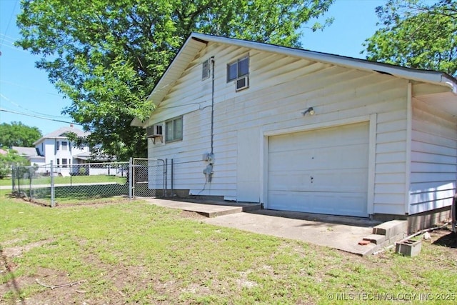 view of side of home featuring a detached garage and a gate