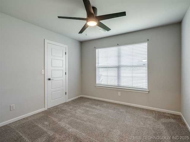 spare room featuring a ceiling fan, carpet floors, and baseboards
