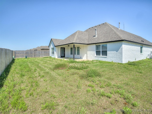 back of house featuring a ceiling fan, roof with shingles, brick siding, and a patio