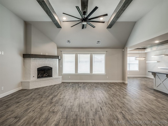 unfurnished living room with ceiling fan, beamed ceiling, a fireplace, baseboards, and high vaulted ceiling