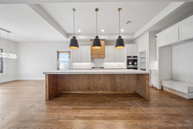 2607 E 135th Dr S, Bixby, OK 74008 - kitchen featuring white cabinetry, wood finished floors, light countertops, stainless steel double oven, and a chandelier