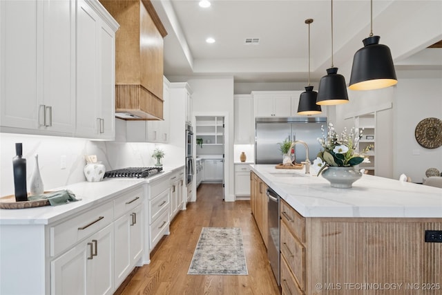 2607 E 135th Dr S, Bixby, OK 74008 - kitchen with stainless steel appliances, a large island, light wood-style floors, custom exhaust hood, and a tray ceiling